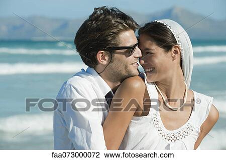 Bride and groom nuzzling at the beach View Large Photo Image Stock Image - Bride and groom nuzzling at the beach. Fotosearch