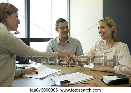 Businesswoman shaking hands with client in office View Large Photo Image Stock Photograph - Businesswoman shaking hands with client in office. Fotosearch