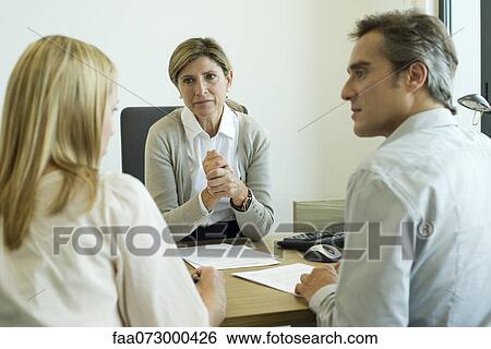 Businesswoman talking with clients in office View Large Photo Image Stock Photograph - Businesswoman talking with clients in office. Fotosearch