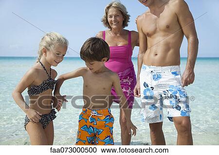 Stock Image - Children holding hands at the beach. Fotosearch