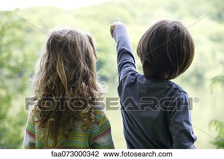 Children looking at lake as boy points View Large Photo Image Stock Image - Children looking at lake as boy points. Fotosearch