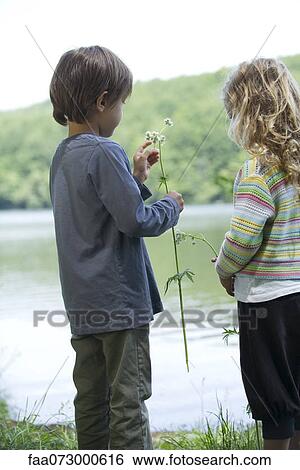 Children looking at wildflowers by lake View Large Photo Image Stock Photograph - Children looking at wildflowers by lake. Fotosearch