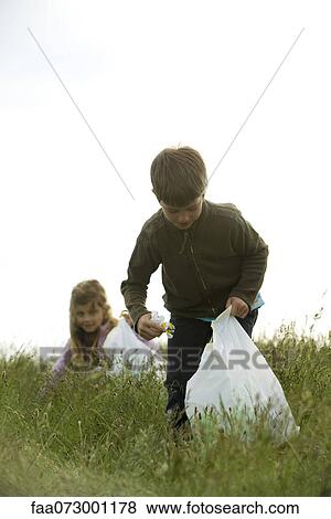 Children picking up trash in field View Large Photo Image Stock Photo - Children picking up trash in field. Fotosearch