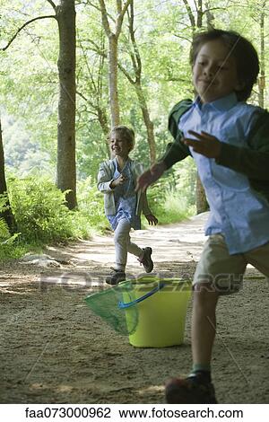 Stock Image - Children running in woods. Fotosearch