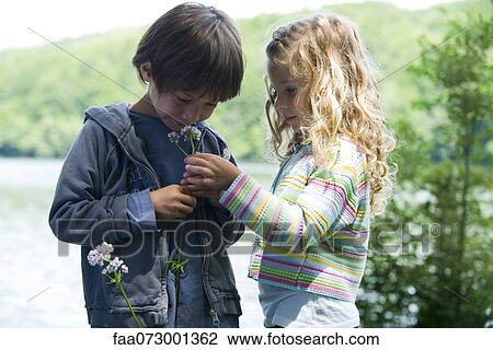 Children smelling wildflowers together outdoors View Large Photo Image Stock Image - Children smelling wildflowers together outdoors. Fotosearch