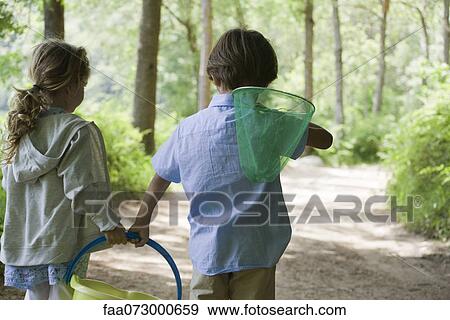 Children walking in woods together with butterfly net and bucket View Large Photo Image Stock Photo - Children walking in woods together with butterfly net and bucket. Fotosearch