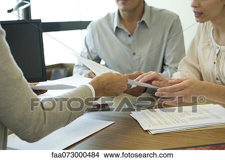 Picture - Clients looking at contract, cropped. Fotosearch