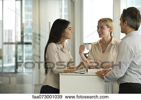 Colleagues chatting together during coffee break View Large Photo Image Stock Photo - Colleagues chatting together during coffee break. Fotosearch