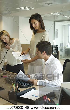 Colleagues collaborating in office View Large Photo Image Stock Image - Colleagues collaborating in office. Fotosearch