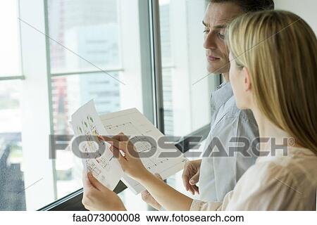 Colleagues discussing blueprints View Large Photo Image Stock Photo - Colleagues discussing blueprints. Fotosearch