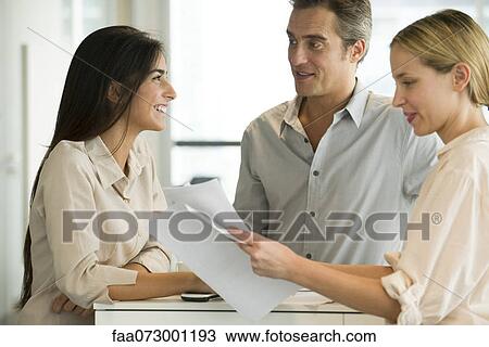 Colleagues talking together in office View Large Photo Image Stock Image - Colleagues talking together in office. Fotosearch