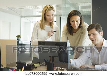 Colleagues working together at computer View Large Photo Image Stock Photo - Colleagues working together at computer. Fotosearch