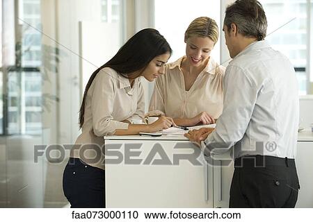 Colleagues working together in office View Large Photo Image Stock Image - Colleagues working together in office. Fotosearch
