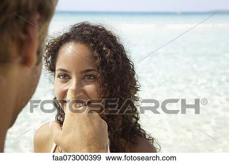 Couple at the beach, man touching woman's nose View Large Photo Image Stock Photo - Couple at the beach, man touching woman's nose. Fotosearch