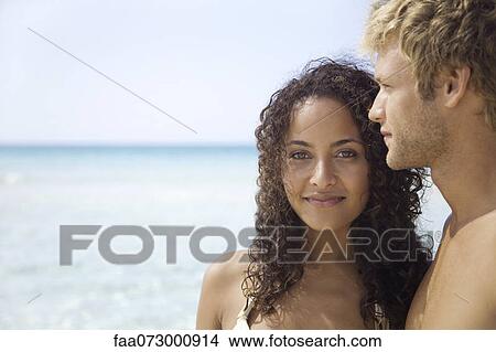 Couple at the beach, portrait View Large Photo Image Picture - Couple at the beach, portrait. Fotosearch