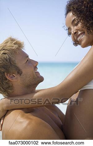 Couple embracing at the beach View Large Photo Image Stock Image - Couple embracing at the beach. Fotosearch