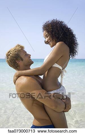 Couple embracing at the beach View Large Photo Image Stock Image - Couple embracing at the beach. Fotosearch