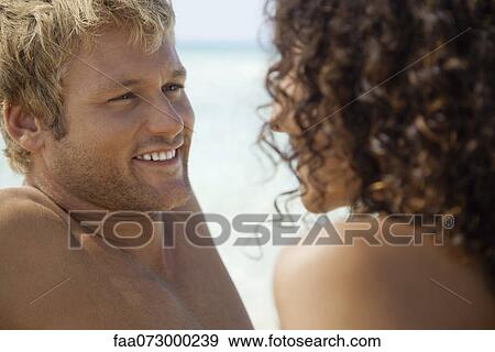 Stock Photo - Couple face to face at the beach. Fotosearch