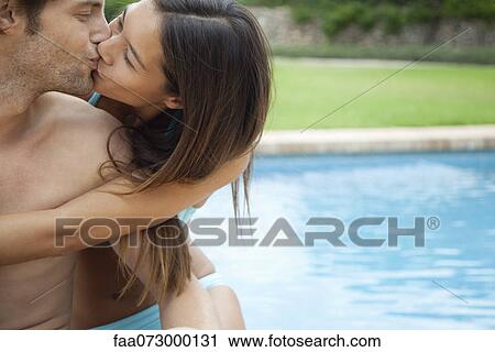Couple kissing by swimming pool View Large Photo Image Stock Image - Couple kissing by swimming pool. Fotosearch