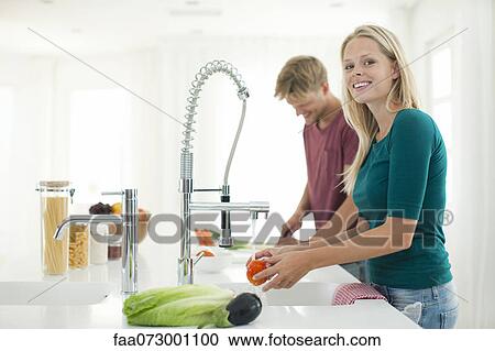 Couple preparing meal together in kitchen View Large Photo Image Stock Image - Couple preparing meal together in kitchen. Fotosearch
