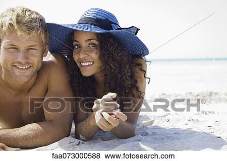 Stock Photo - Couple relaxing at the beach, portrait. Fotosearch