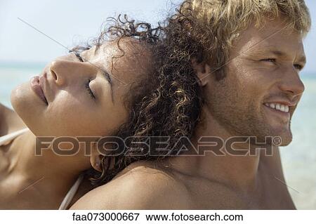 Stock Photo - Couple relaxing at the beach. Fotosearch