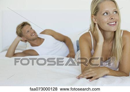Stock Photo - Couple relaxing on bed. Fotosearch