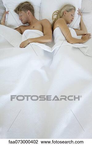 Stock Image - Couple sleeping in bed. Fotosearch