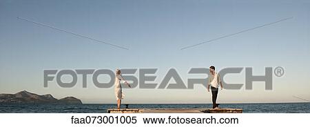 Couple standing on pier View Large Photo Image Stock Photography - Couple standing on pier. Fotosearch
