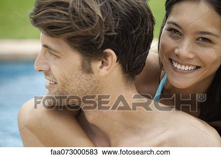 Stock Image - Couple together at poolside, portrait. Fotosearch