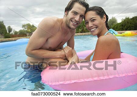 Picture - Couple together in swimming pool, portrait. Fotosearch