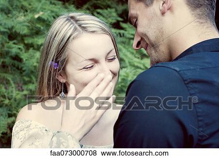 Couple together outdoors, woman laughing and covering her mouth View Large Photo Image Stock Photo - Couple together outdoors, woman laughing and covering her mouth. Fotosearch