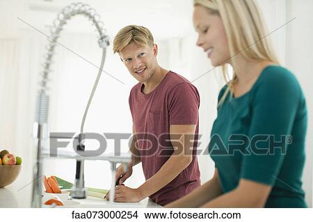 Couple working together in kitchen View Large Photo Image Picture - Couple working together in kitchen. Fotosearch