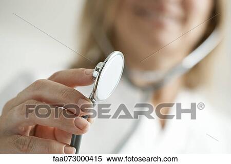 Stock Photography - Doctor holding out stethoscope, cropped. Fotosearch