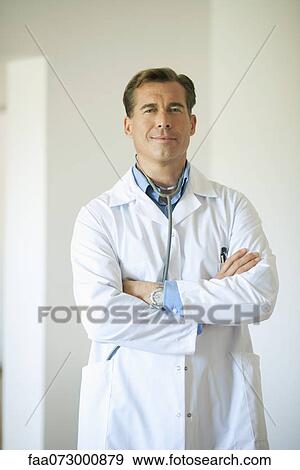 Stock Photo - Doctor standing with arms folded, portrait. Fotosearch