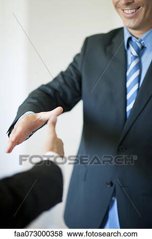 Executives extending hands to shake, cropped View Large Photo Image Stock Photo - Executives extending hands to shake, cropped. Fotosearch