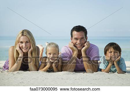 Family lying on sand at the beach, portrait View Large Photo Image Stock Photography - Family lying on sand at the beach, portrait. Fotosearch