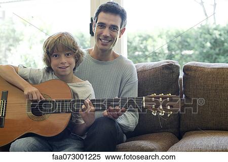 Father teaching son how to play guitar View Large Photo Image Stock Photography - Father teaching son how to play guitar. Fotosearch