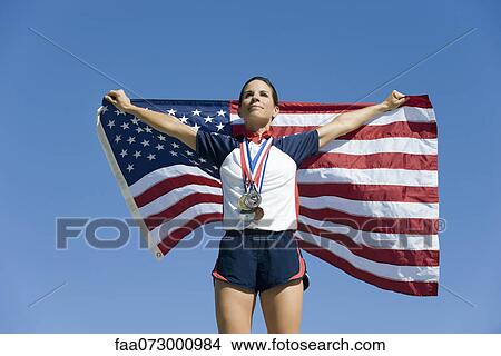 Female athlete being honored on podium, holding up American flag View Large Photo Image Picture - Female athlete being honored on podium, holding up American flag. Fotosearch
