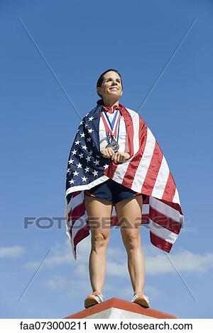 Female athlete being honored on podium, wrapped in American flag View Large Photo Image Stock Image - Female athlete being honored on podium, wrapped in American flag. Fotosearch