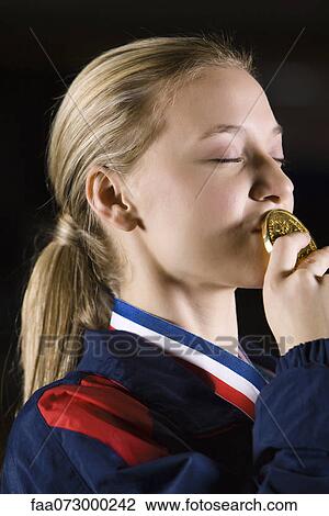 Female athlete kissing gold medal View Large Photo Image Stock Image - Female athlete kissing gold medal. Fotosearch