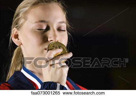 Female athlete kissing gold medal, portrait View Large Photo Image Stock Photography - Female athlete kissing gold medal, portrait. Fotosearch