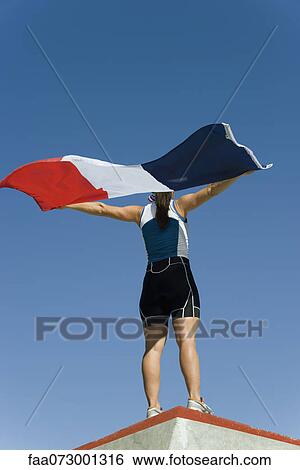 Female athlete on winner's podium, holding up French flag View Large Photo Image Stock Photograph - Female athlete on winner's podium, holding up French flag. Fotosearch