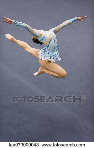 Female gymnast jumping in midair View Large Photo Image Stock Image - Female gymnast jumping in midair. Fotosearch