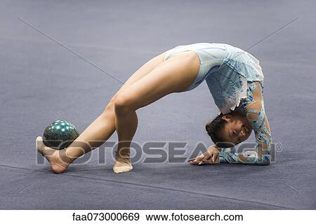 Female gymnast performing floor routine with ball View Large Photo Image Stock Photo - Female gymnast performing floor routine with ball. Fotosearch