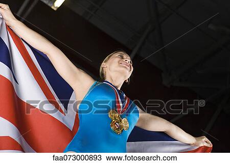 Female gymnastic medalist holding American flag, portrait View Large Photo Image Stock Image - Female gymnastic medalist holding American flag, portrait. Fotosearch