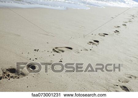 Stock Image - Footprints in sand at the beach. Fotosearch
