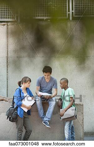 Friends discussing homework together View Large Photo Image Stock Photo - Friends discussing homework together. Fotosearch
