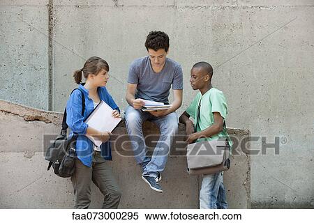 Friends discussing homework together View Large Photo Image Stock Photography - Friends discussing homework together. Fotosearch