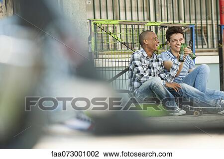 Friends sitting on sidewalk toasting View Large Photo Image Stock Image - Friends sitting on sidewalk toasting. Fotosearch